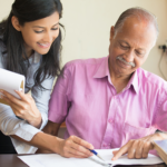 volunteer helping older man with paperwork